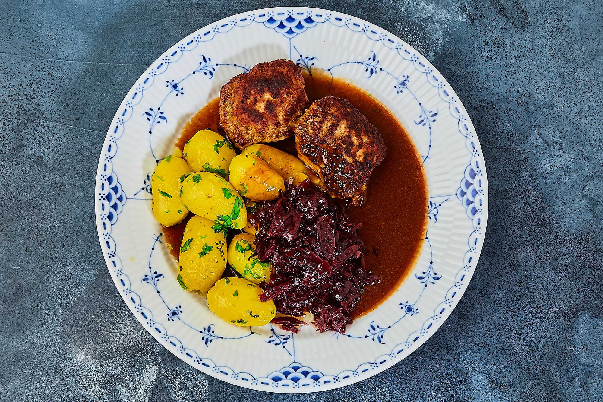 Frikadeller med skysovs, kartofler og rødkål