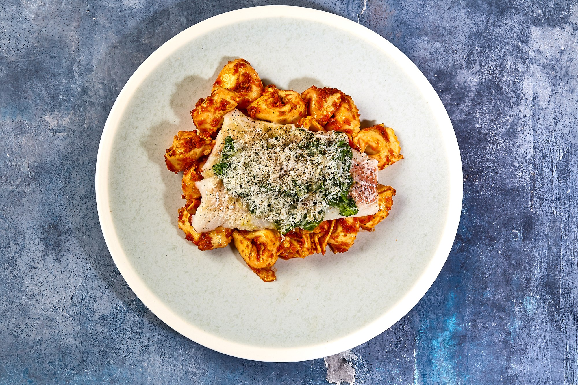 Tortellini med tomat og mozzarella i romescosauce dertil bagt kuller og parmesanstegt rucola